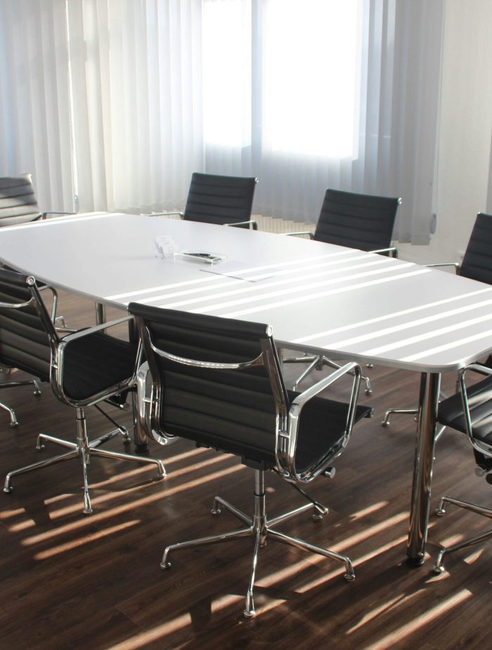 Modern office meeting room with designer chairs, table, and large windows.